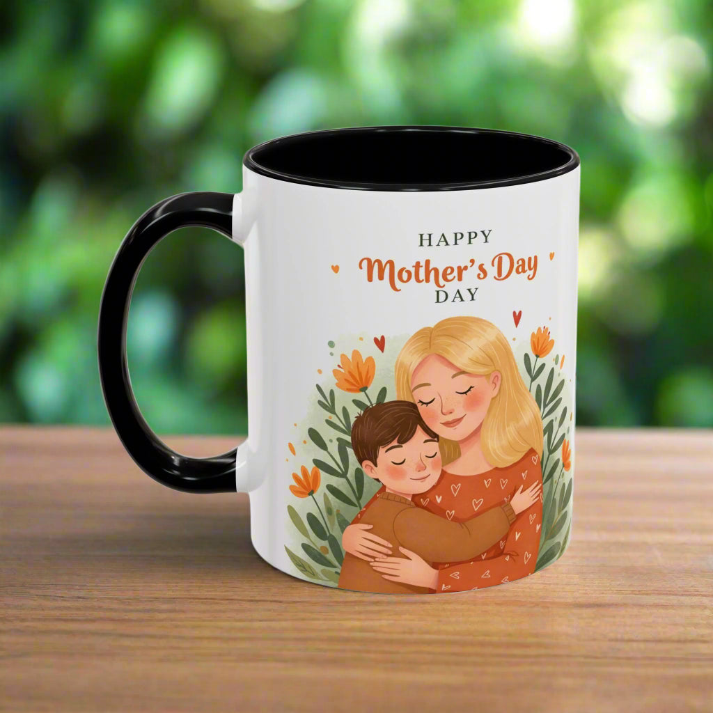 A white ceramic coffee mug with a black handle and interior, featuring an illustration of a mother embracing her child with a 'Happy Mother's Day' message, surrounded by floral accents.