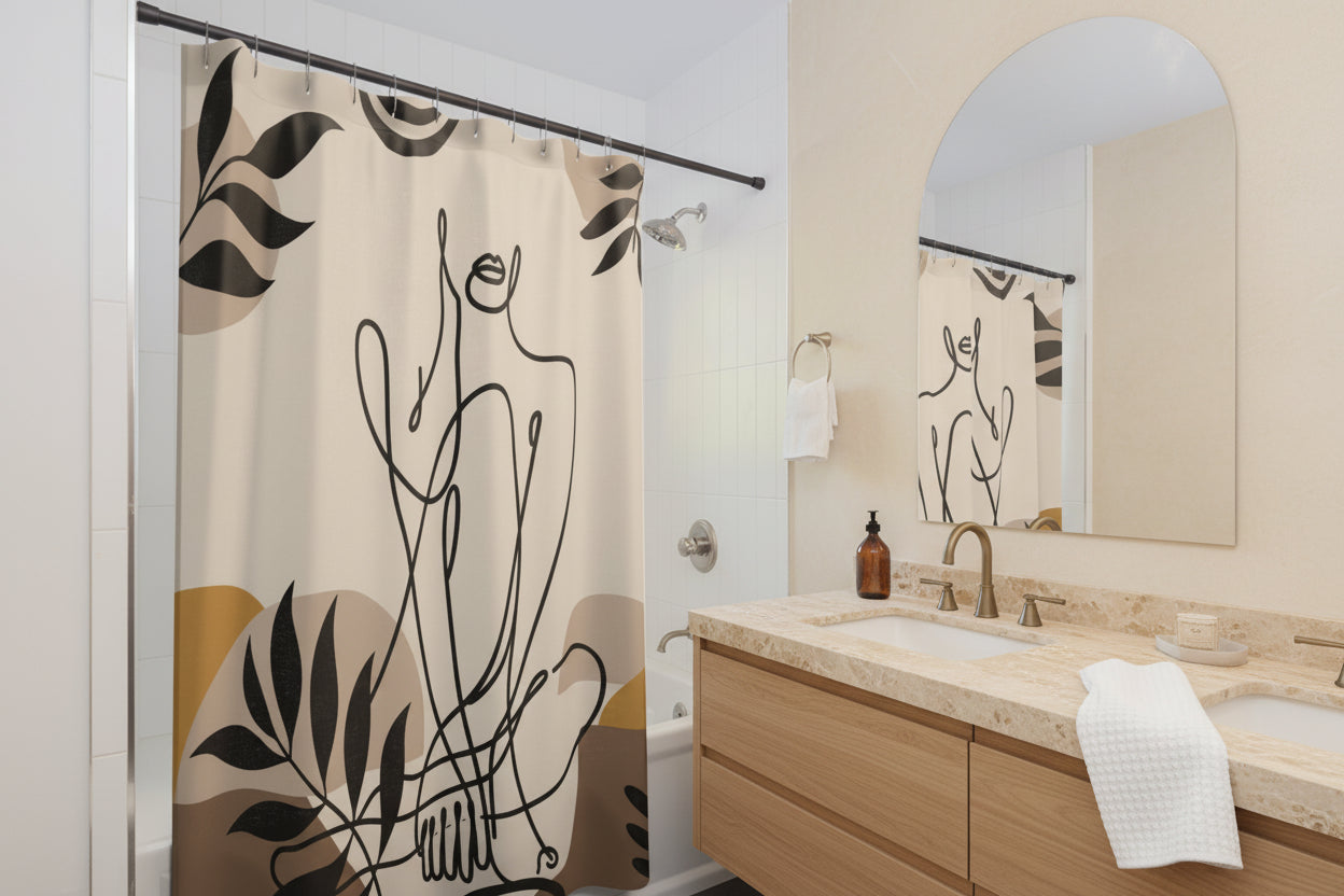 A beige shower curtain with a black minimalist line art design of a figure and leaves, hanging in a modern white and blue-gray bathroom.