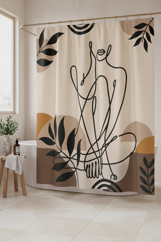 Beige shower curtain with black figure and leaf artwork beside a sunlit window and a small wooden stool.