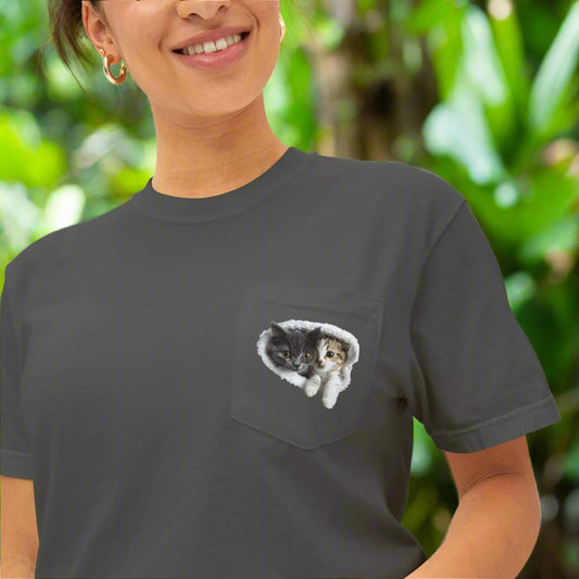 Person wearing a dark gray t-shirt with a pocket featuring an illustration of two cats.