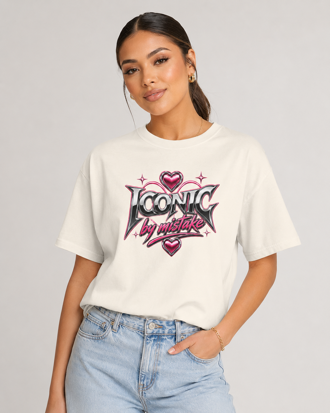 Person wearing a white t-shirt with 'Iconic by mistake' design on a plain background