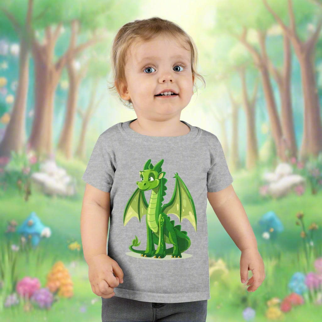 A toddler wearing a gray t-shirt with a cute green dragon graphic in the center.