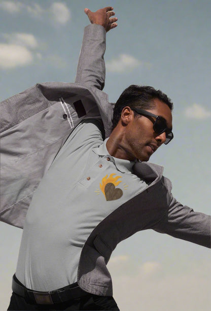 A man wearing a gray jacket with a heart design in polo tee
