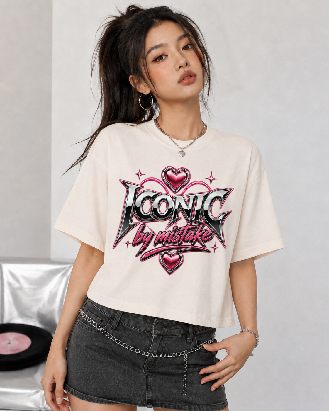 Woman wearing a white t-shirt with 'Iconic by mistake' design on a gray background